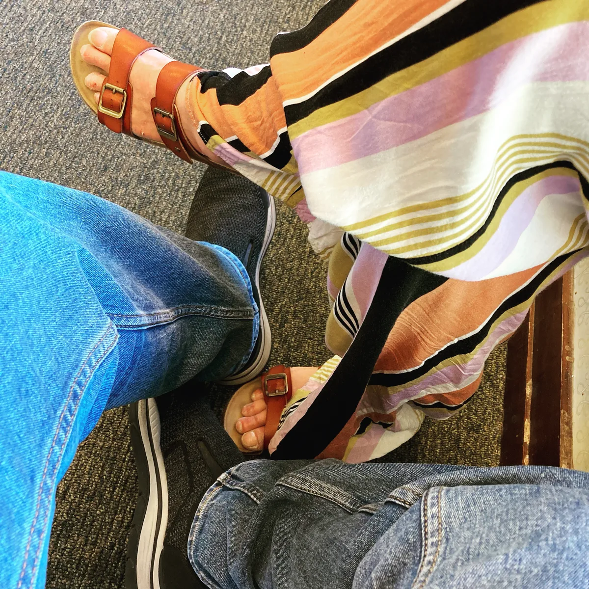 Overhead shot of Thad and Jolynn's shoes and legs while sitting in chairs together at Barnes and Noble.