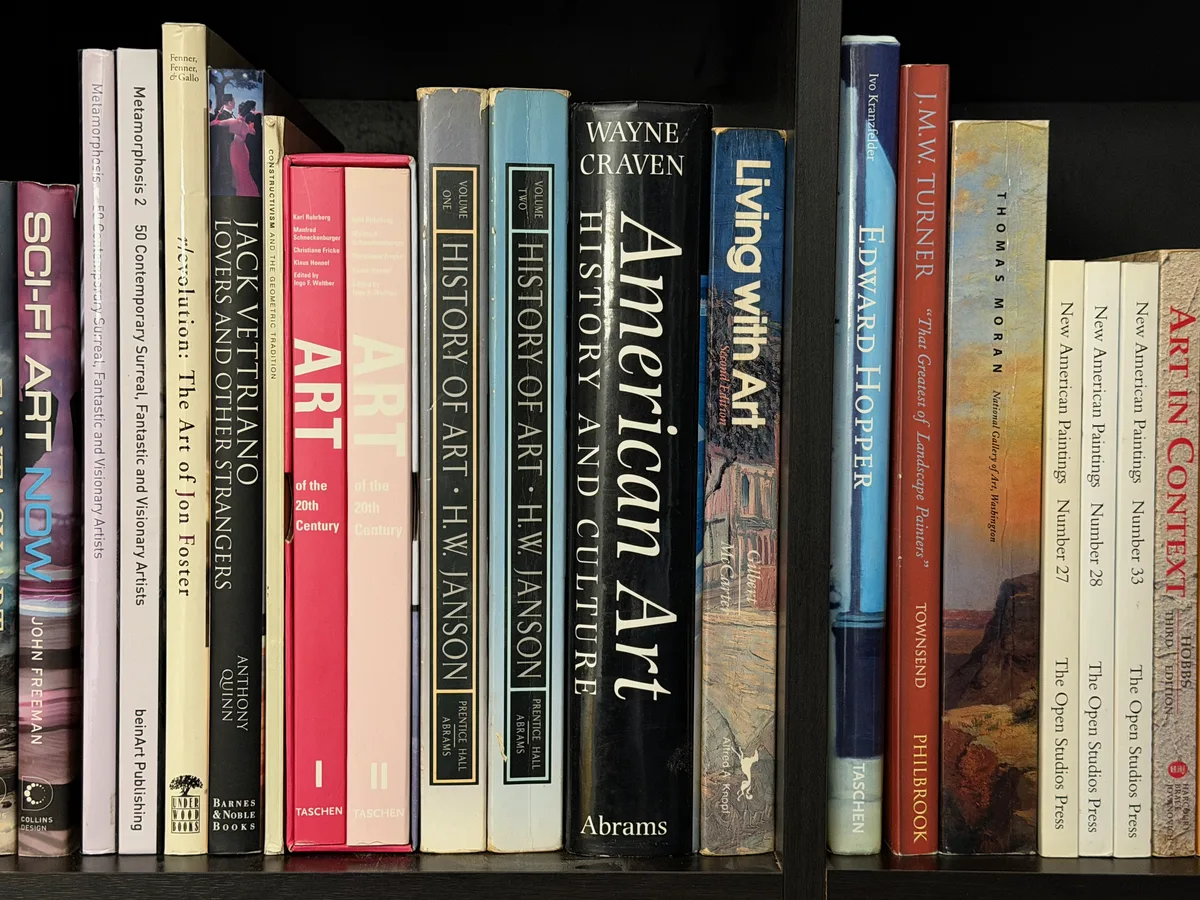 A shelf of art books, spines facing out, including titles on art history, painters, and contemporary artists.