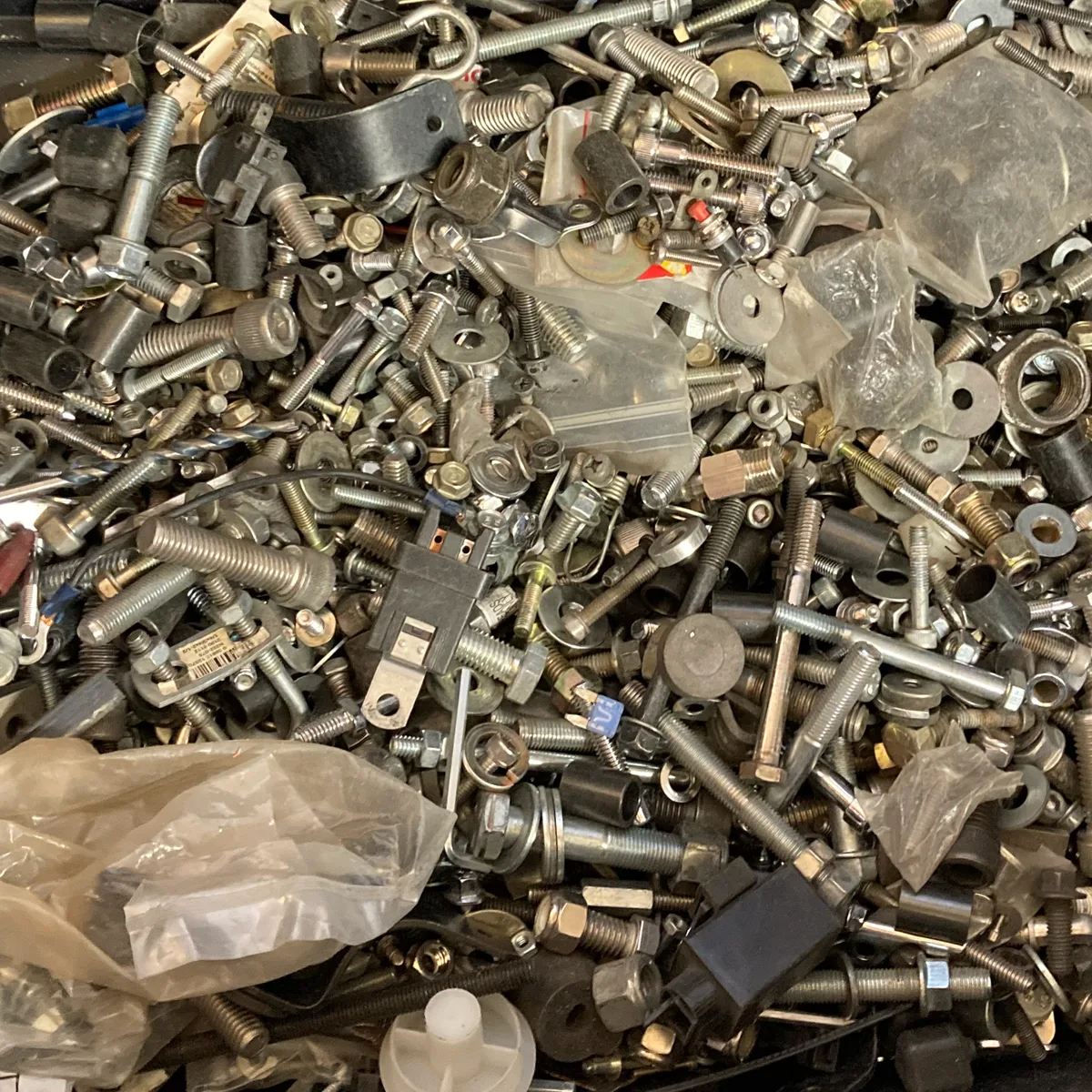 A large pile of mixed screws, bolts, and hardware parts