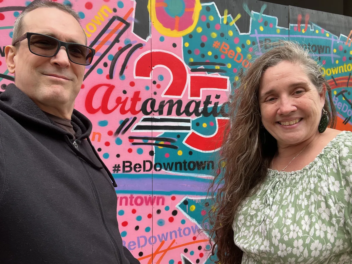 Thad and Jolynn standing in front of a colorful Artomatic mural in Washington, D.C.