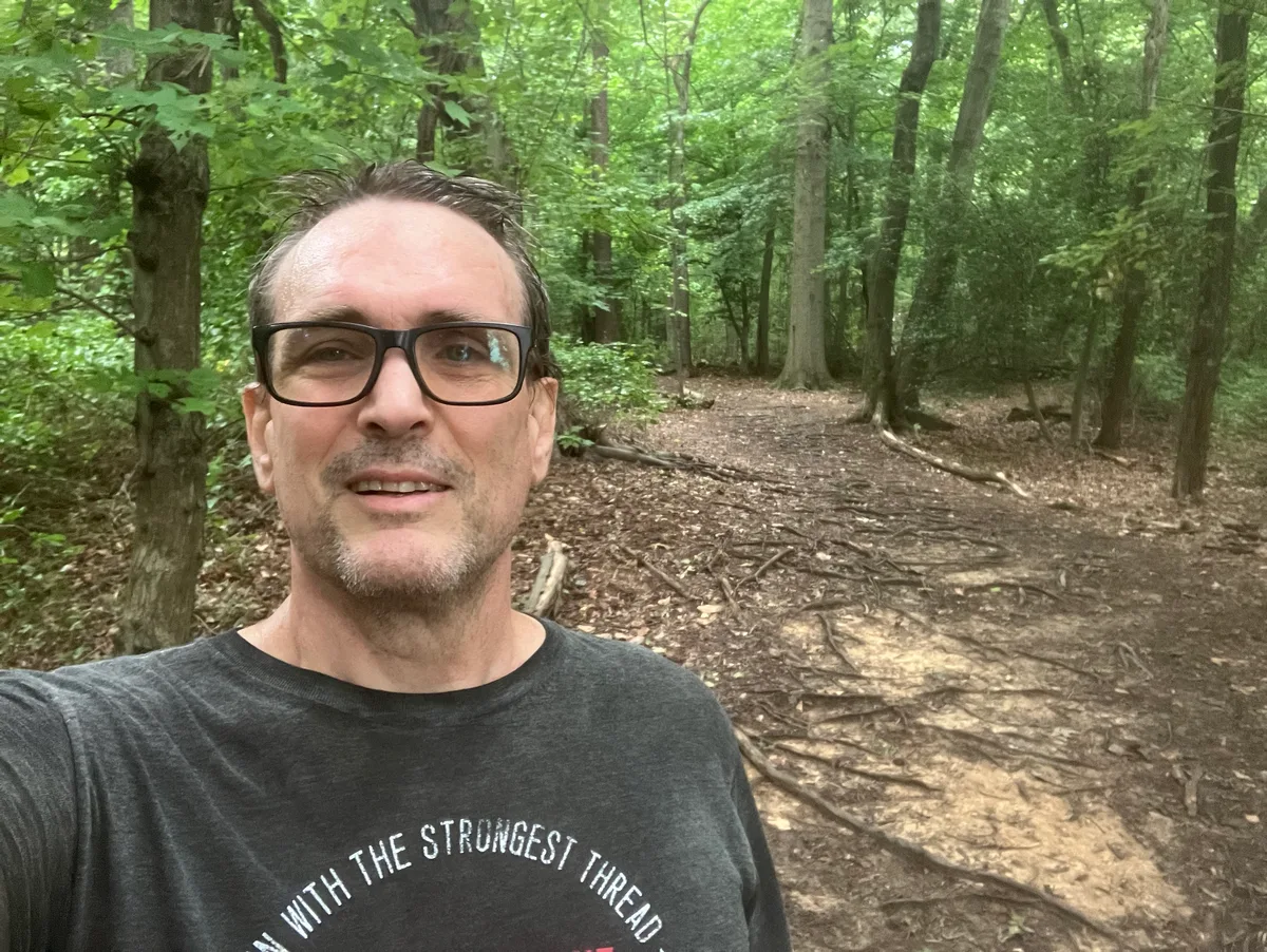 Thad taking a selfie on a wooded trail