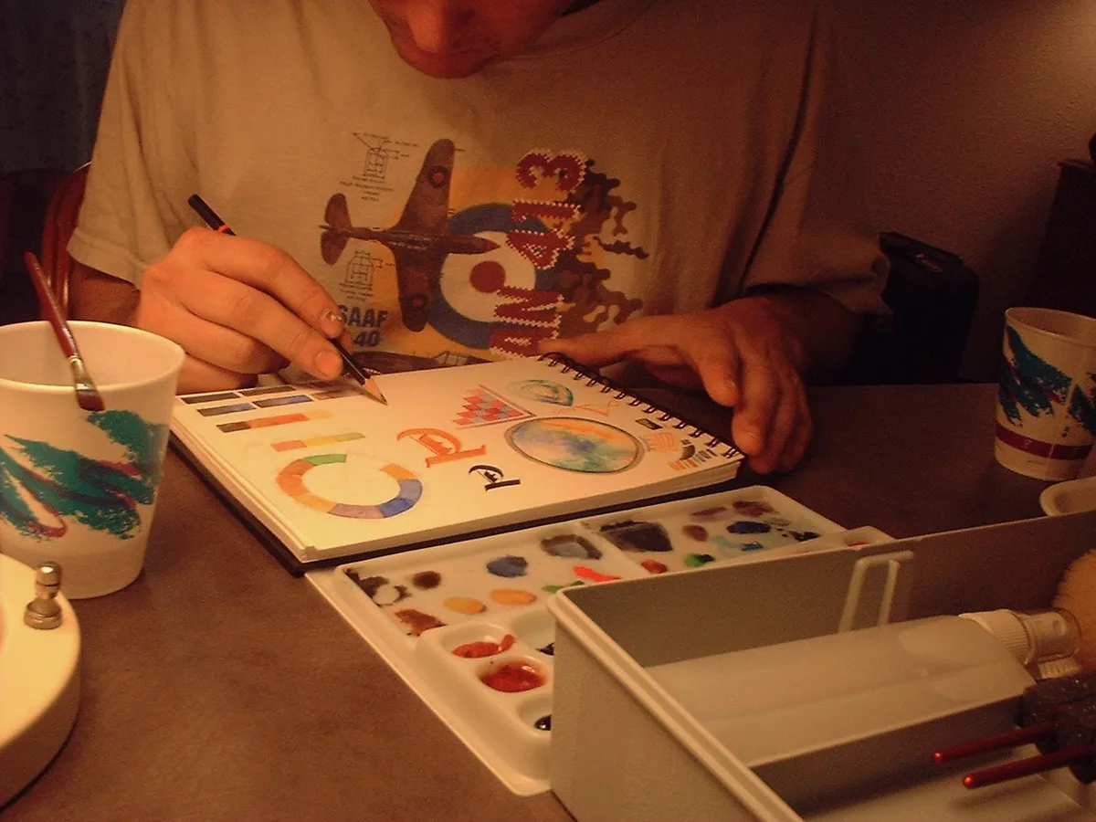 Thad watercolor sketching in a notebook at a hotel table