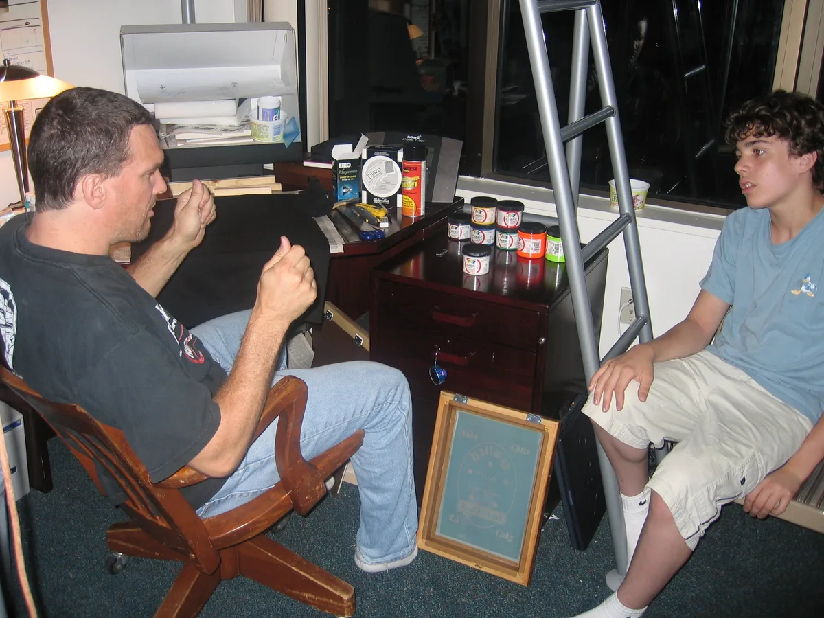 Thad explaining screen printing to his son Ando