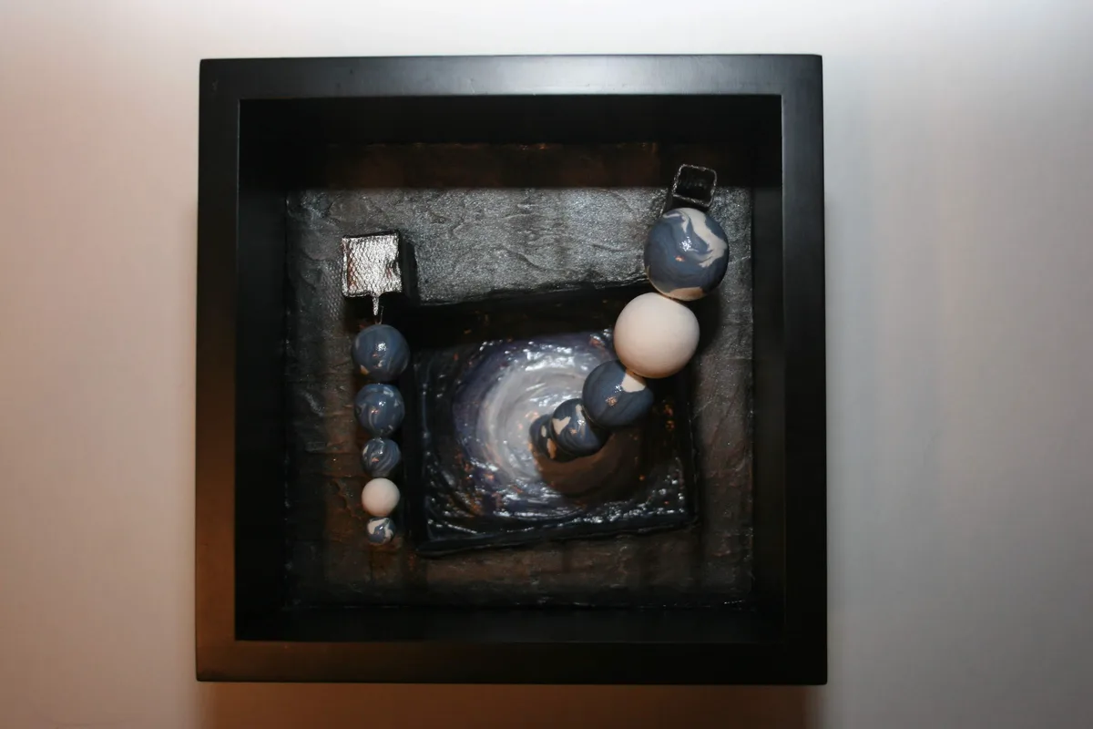 Front view of the completed mixed media piece, framed in black.