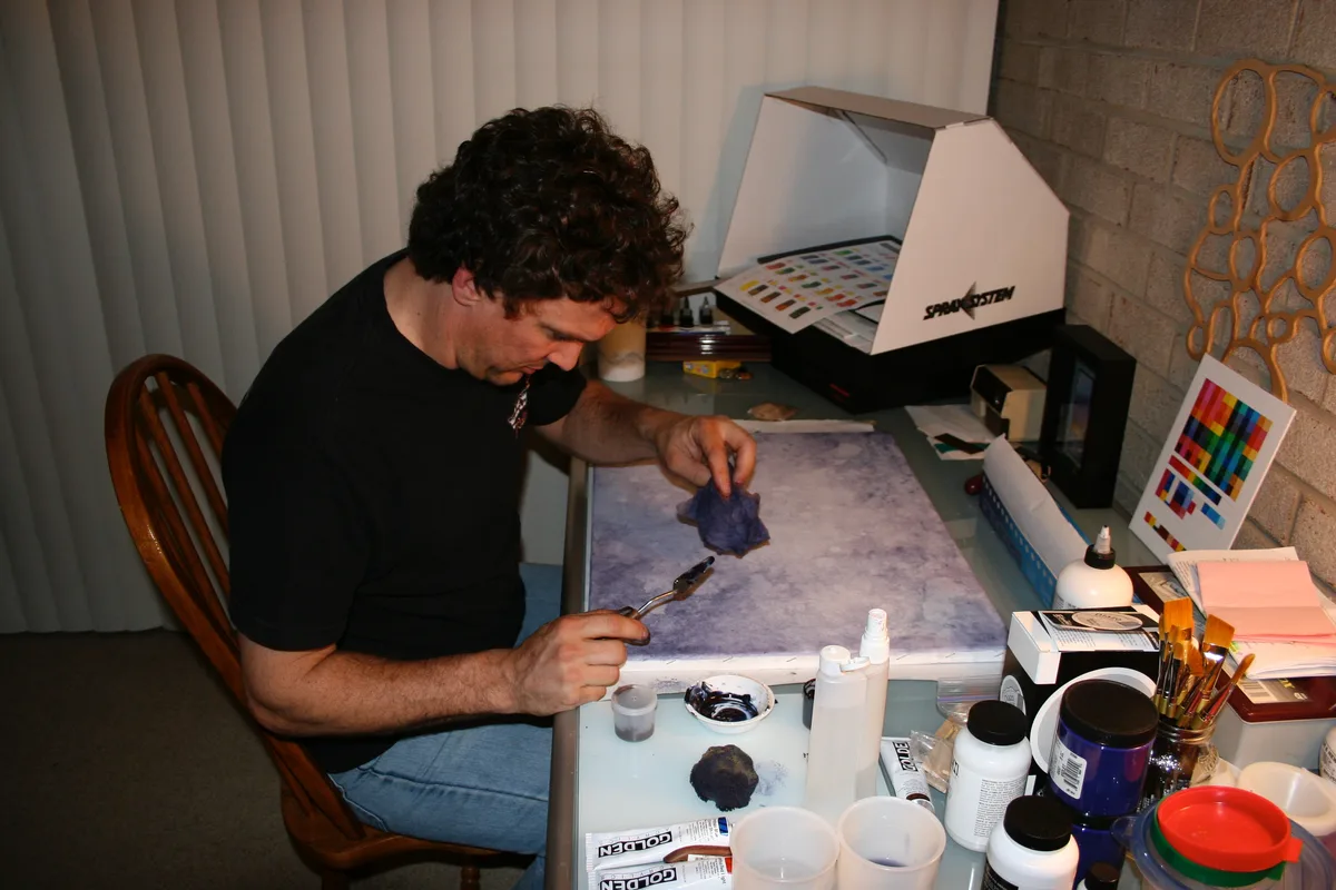 Thad working on the textured background painting at his desk
