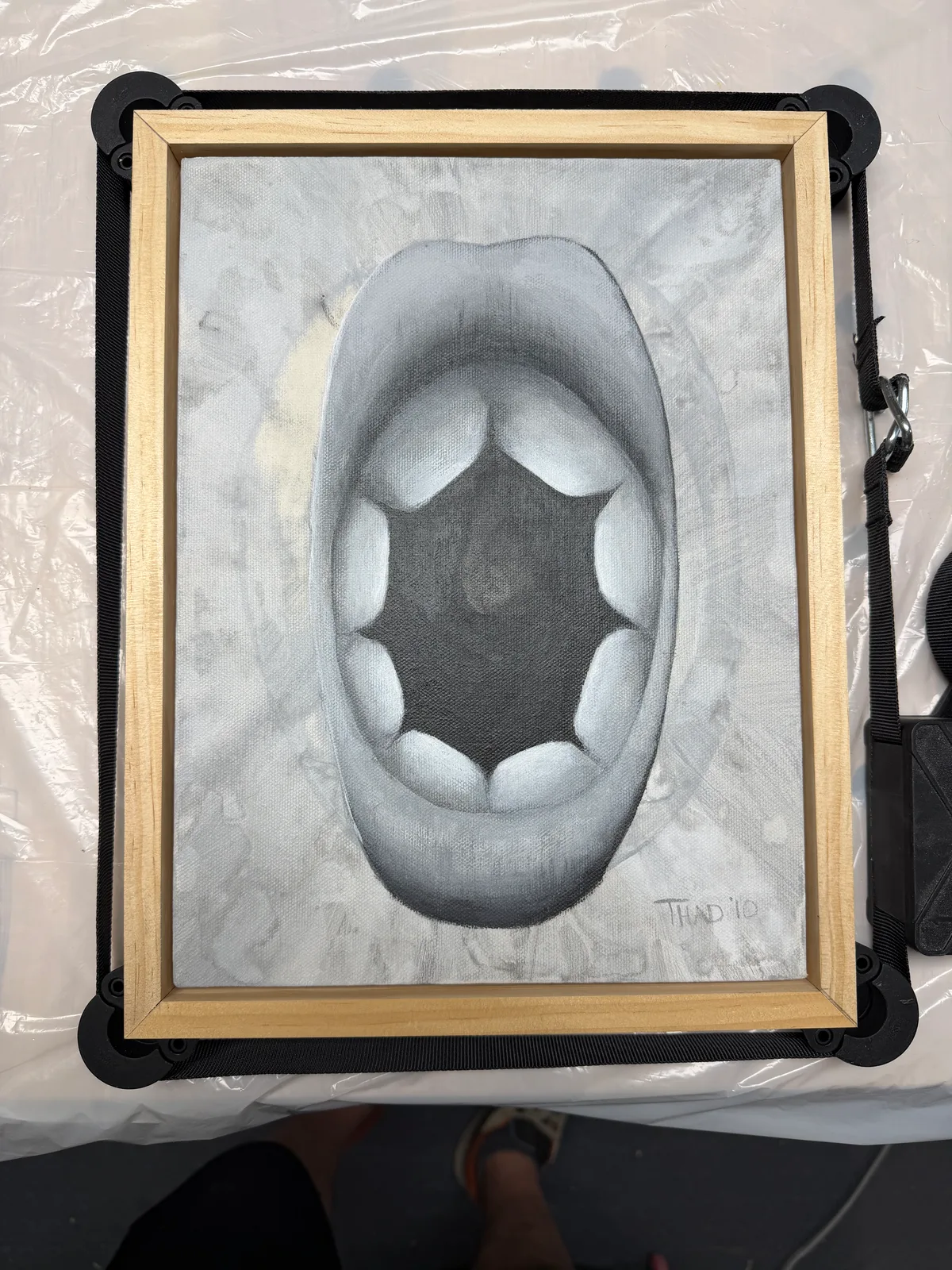The painting inside a wood frame during a dry fit, corner clamps holding the joints in place.